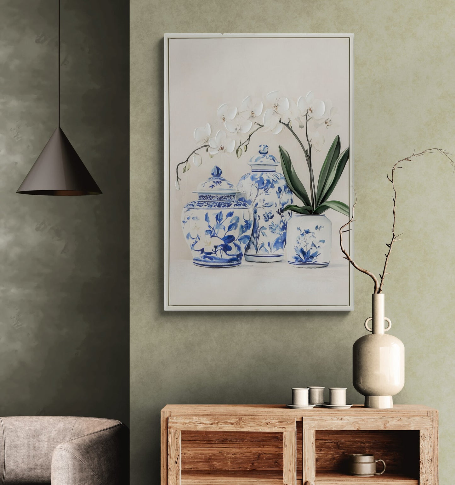 Framed artwork of blue and white ceramic jars on a green wall above a wooden console table.