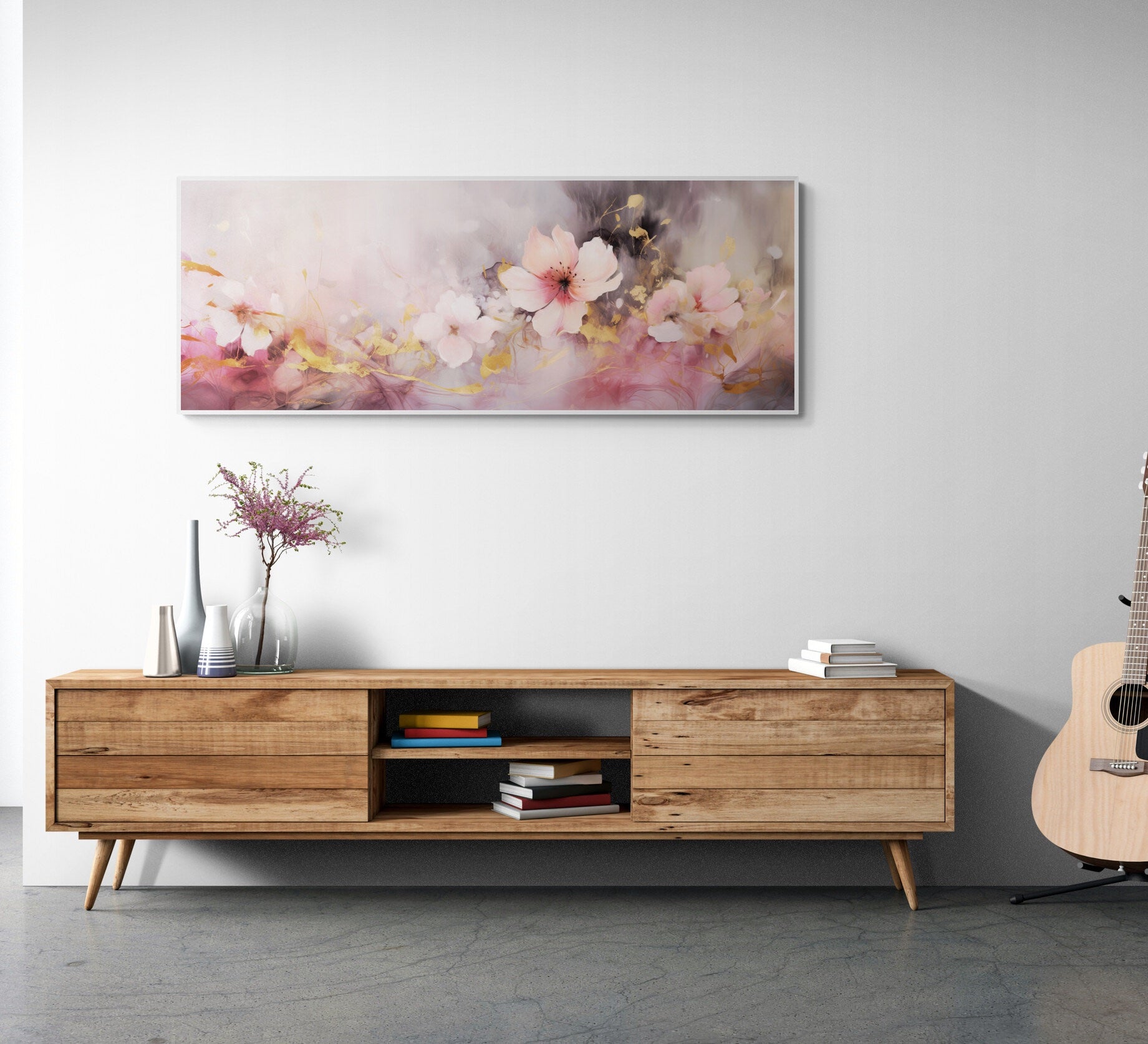 Wooden entertainment console with books and a guitar, floral painting on the wall.
